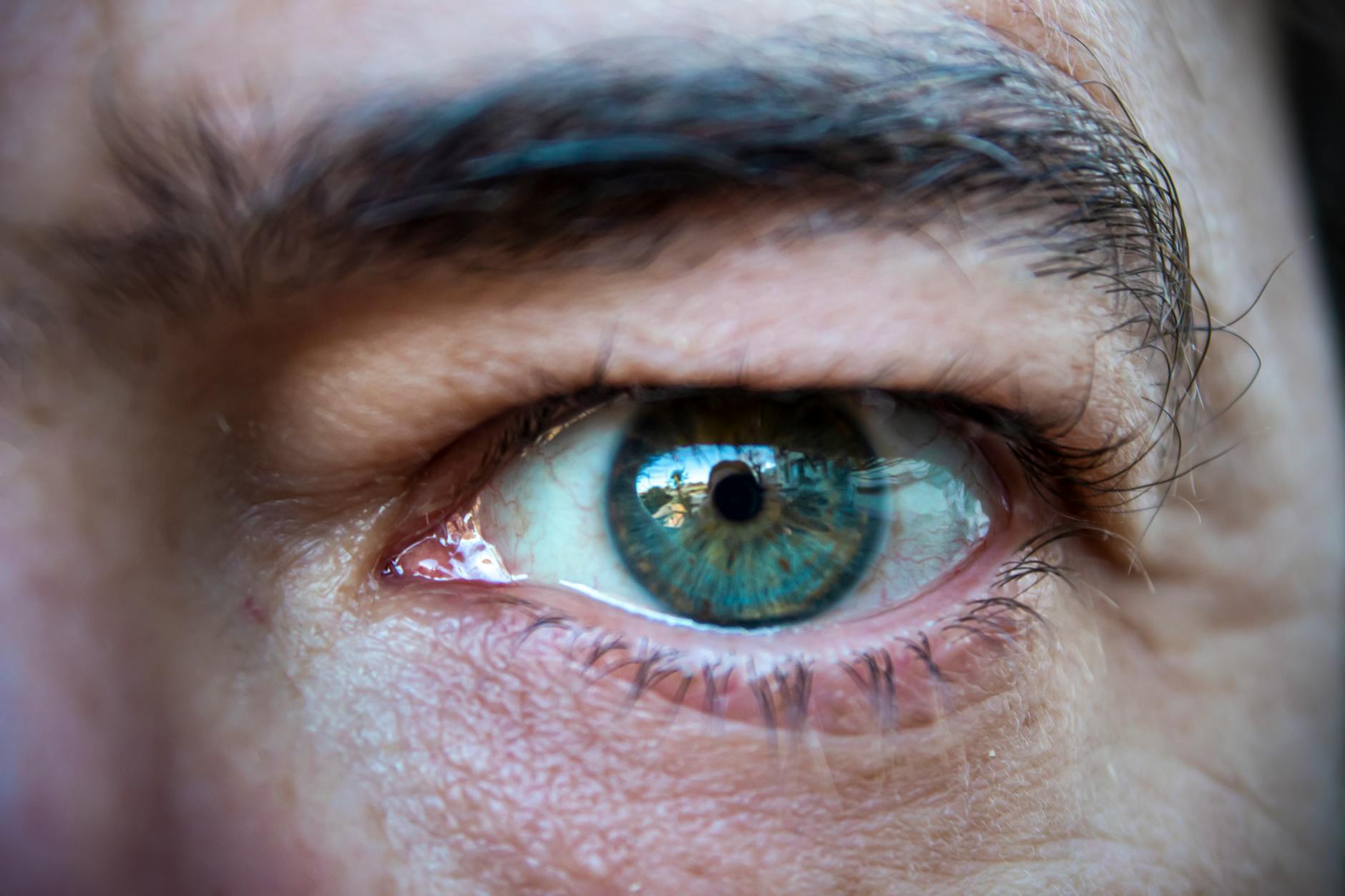 Bir kişinin yanındaki arkadaşına veya iş arkadaşına kıskançlık, haset ve gizli bir öfkeyle bakışını temsil eden dramatik yakın çekim görsel.