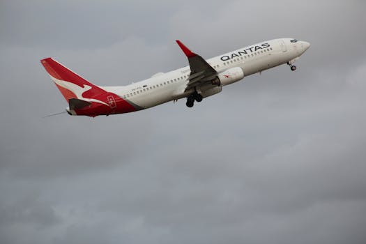 Qantas Boeing 737-800 aircraft taking off into the cloudy sky at Melbourne Airport.