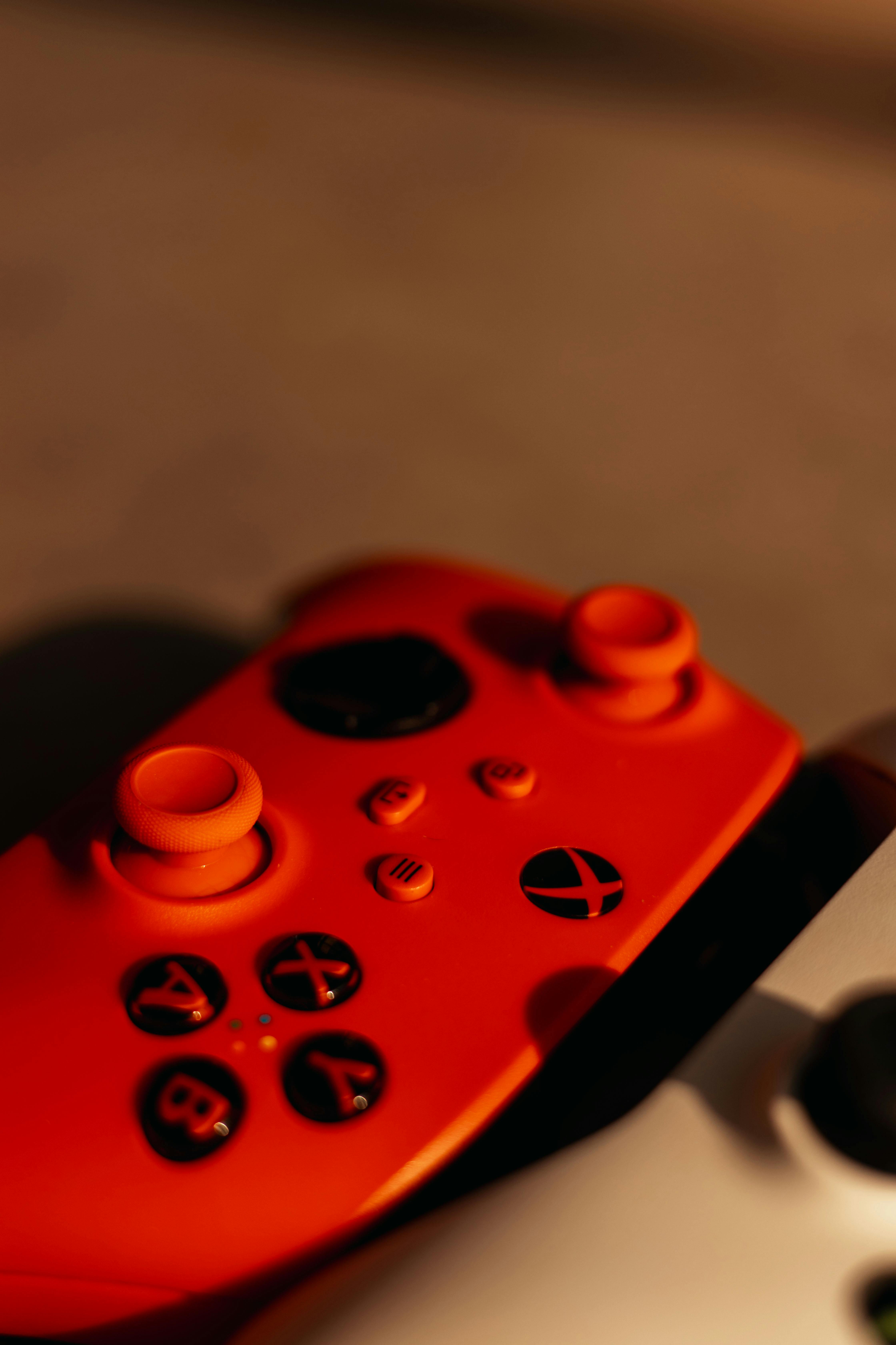 A vibrant red and black gaming controller in focus, ideal for gaming enthusiasts and tech blogs.