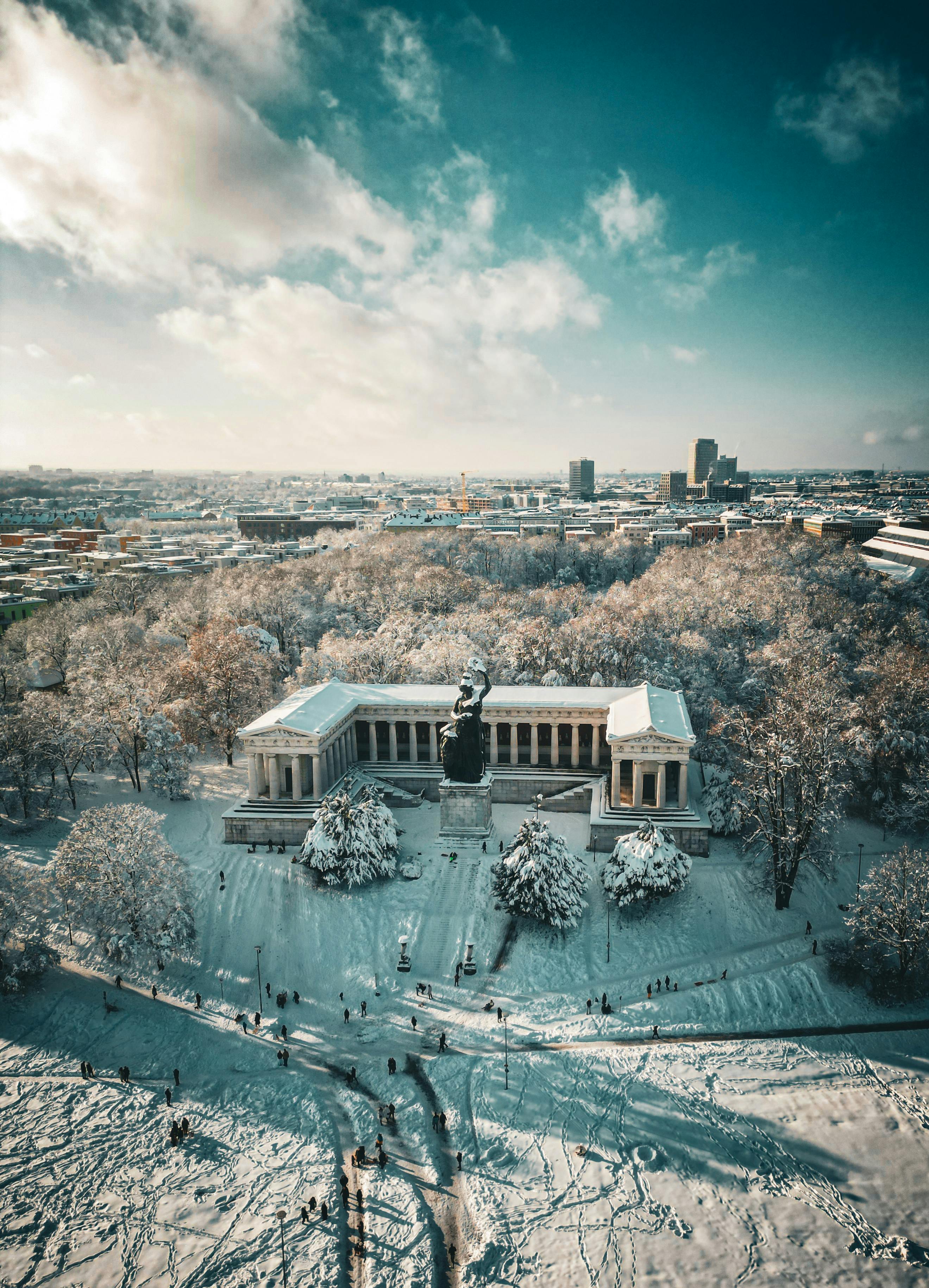 Breathtaking aerial shot of snowy Munich featuring the Bavaria statue and Hall of Fame in winter.