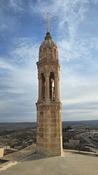 Ancient bell tower in a serene open landscape with a cloudy sky, conveying timeless beauty. — photo by ewngnl