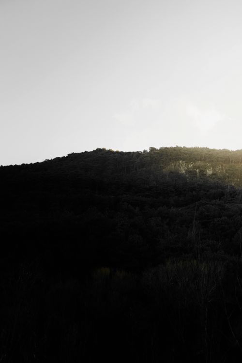 Free A serene mountain silhouette under a soft sunrise sky, perfect for peaceful landscape themes. Stock Photo