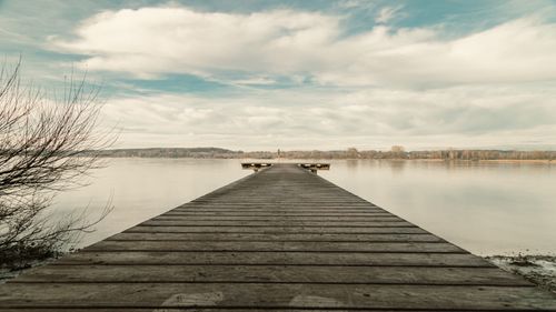Free Tranquil winter scene featuring a wooden pier on Ammersee lake, Bavaria, Germany. Stock Photo