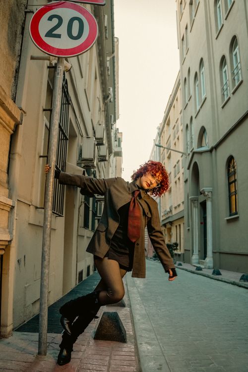 Free Fashionable model poses in a vintage Istanbul street with red hair and elegant attire, embracing urban vibes. Stock Photo