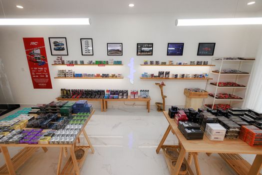Interior of a diecast car model store in Phnom Penh showcasing wooden furniture and colorful model cars.