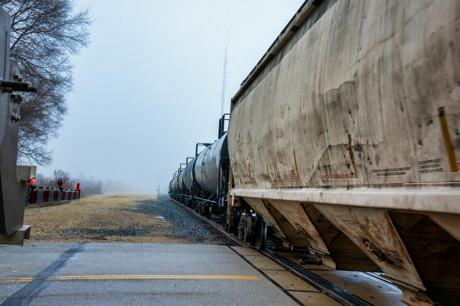 Freight train moving through foggy countryside in Wabasha, Minnesota, on a misty day.