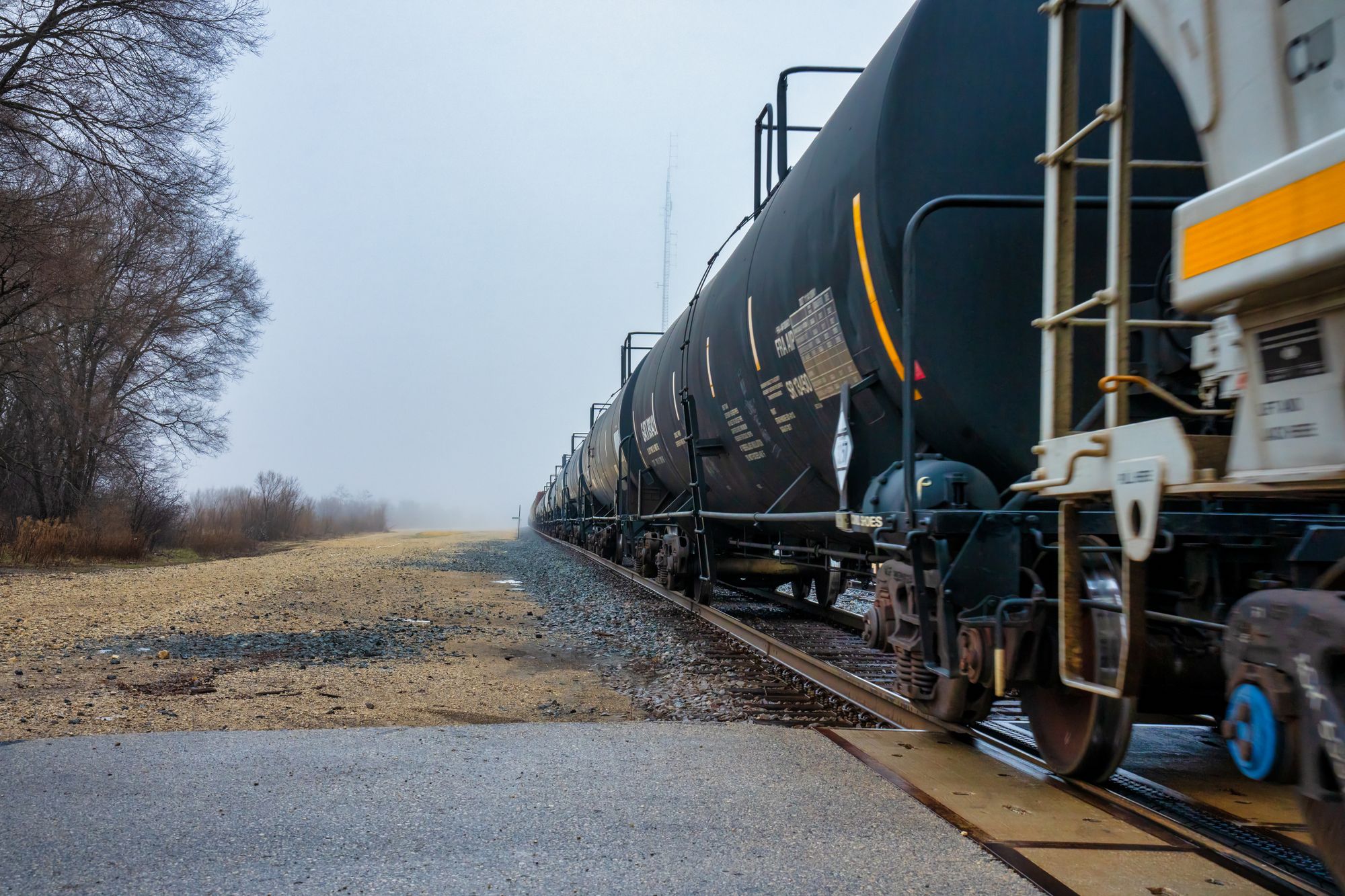 Black tank railcars staged on a track at a rail facility