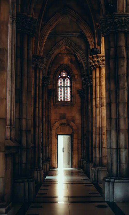 Free Stunning view of a Gothic cathedral interior with a beam of light through stained glass window. Stock Photo