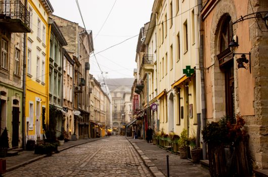 A picturesque view of a quiet European street showcasing historic architecture and cobblestone pathway.