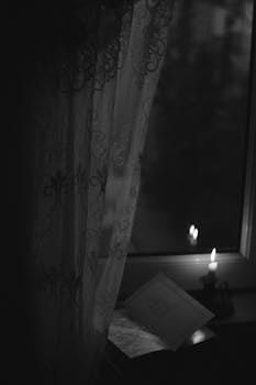 A serene candlelit window setting with lace curtains creating a vintage ambiance.