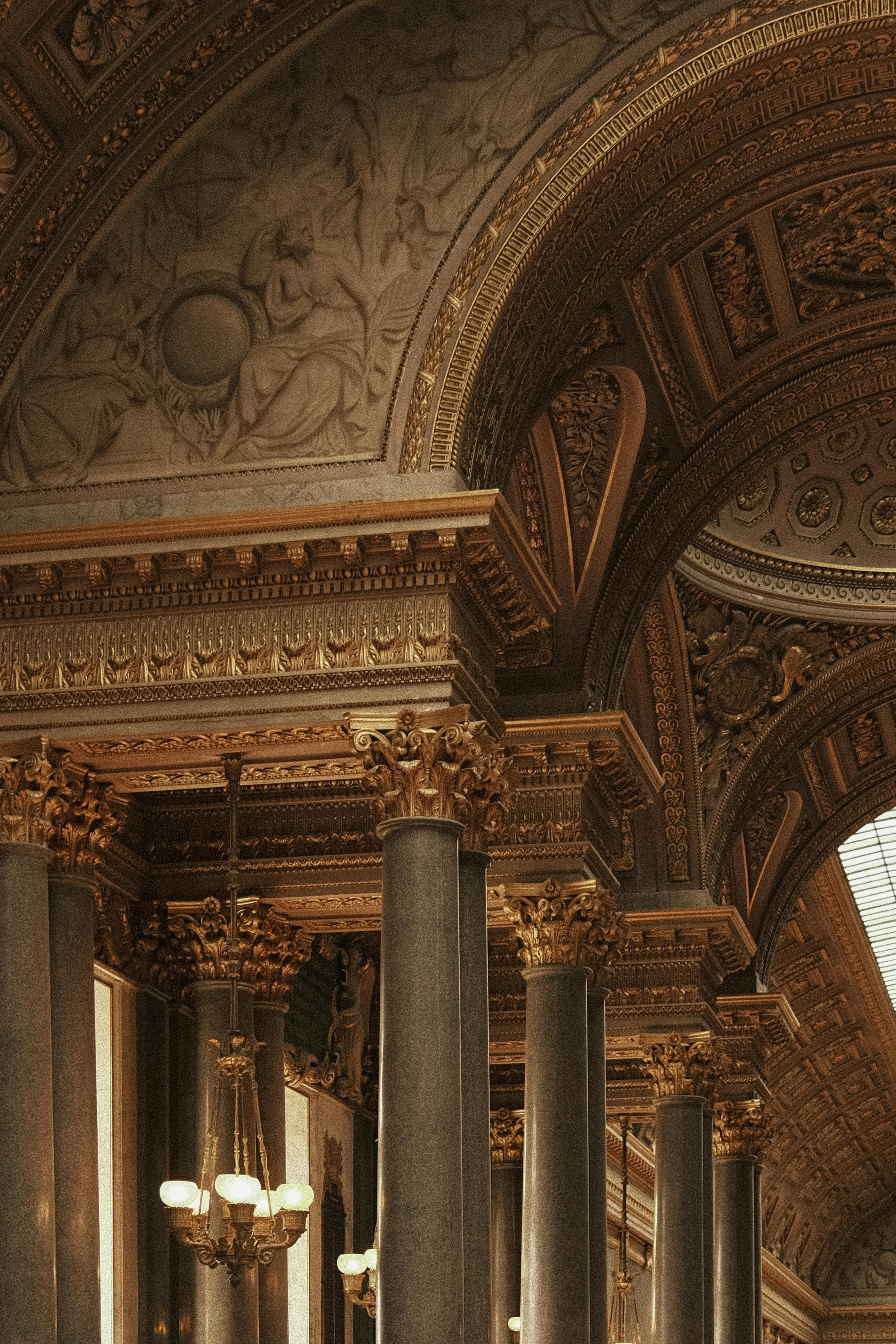 Elegant ornate architecture featuring gold accents and classical columns in warm lighting.