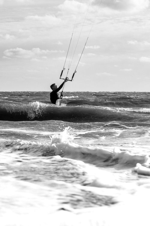 Free Thrilling black and white kitesurfing scene in Exmouth, UK, capturing dynamic ocean waves. Stock Photo