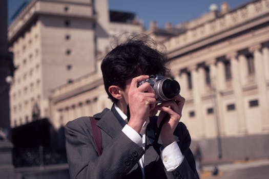 A fashionable young man using a vintage camera on the streets of Buenos Aires.