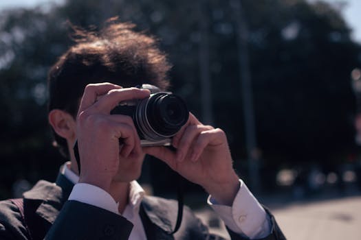 A trendy young man taking photos with a vintage camera on the streets of Buenos Aires, Argentina.