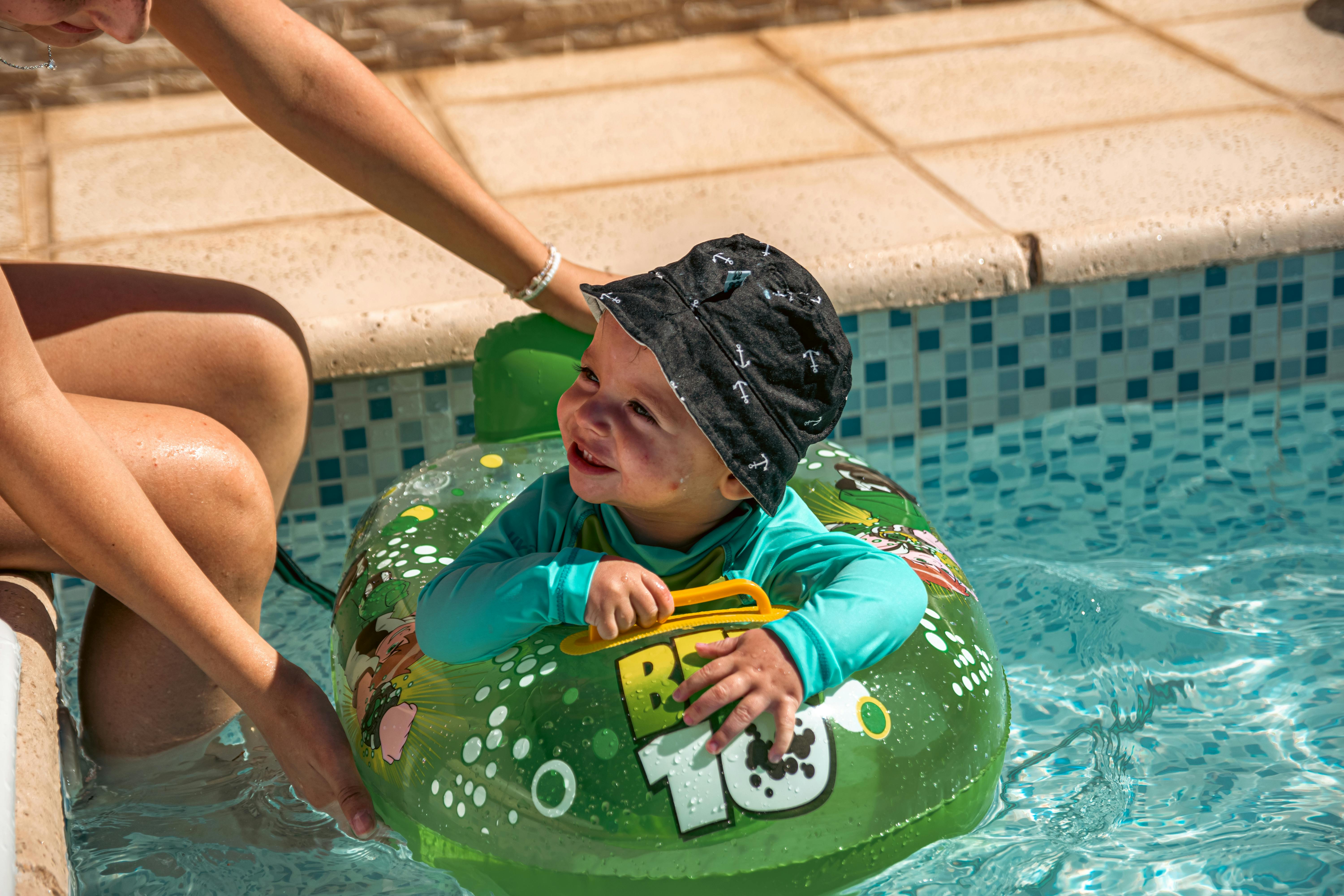 happy infant floating with neck ring in therapy pool - flotation collar
