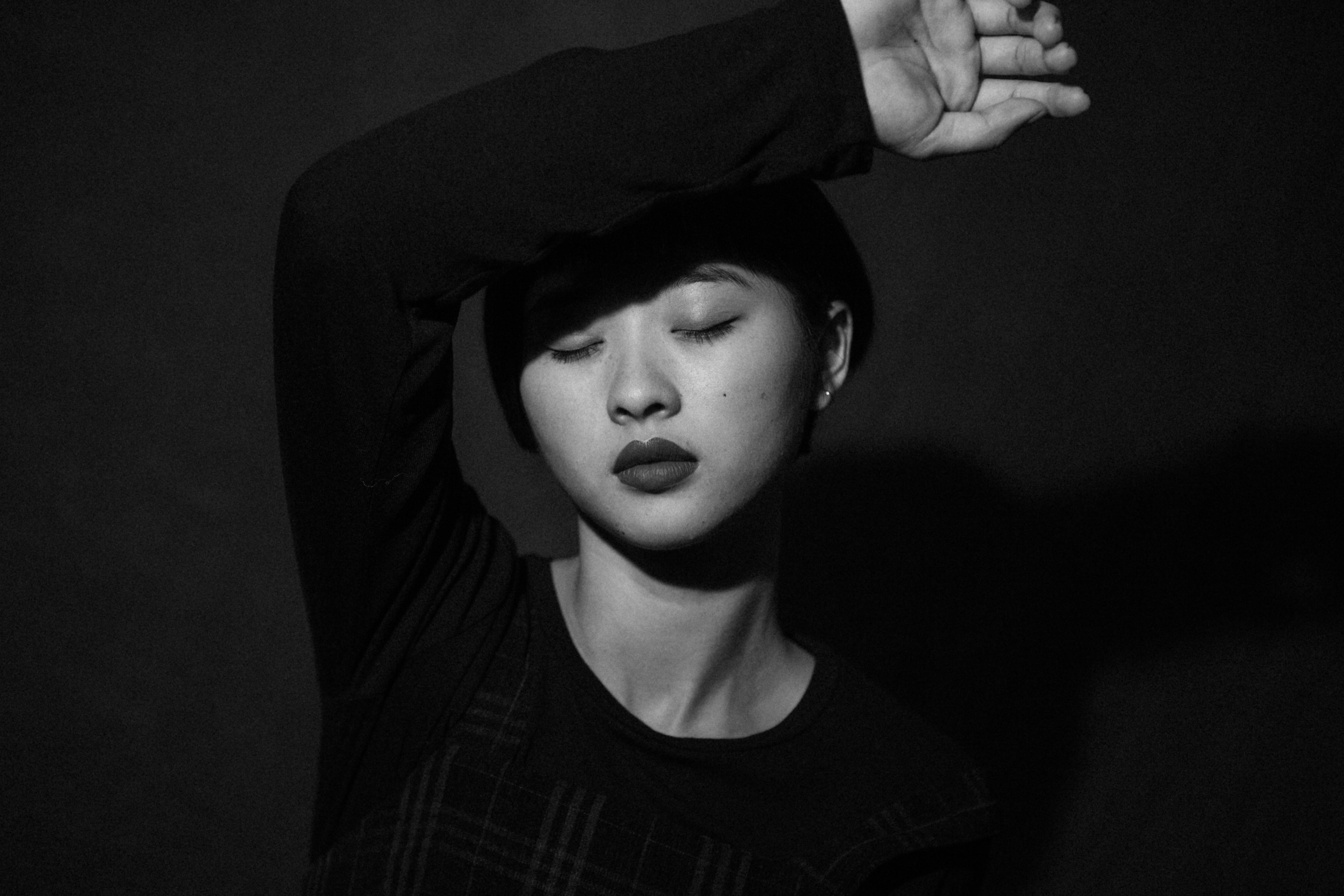 Artistic black and white portrait of a woman with closed eyes, capturing emotion.