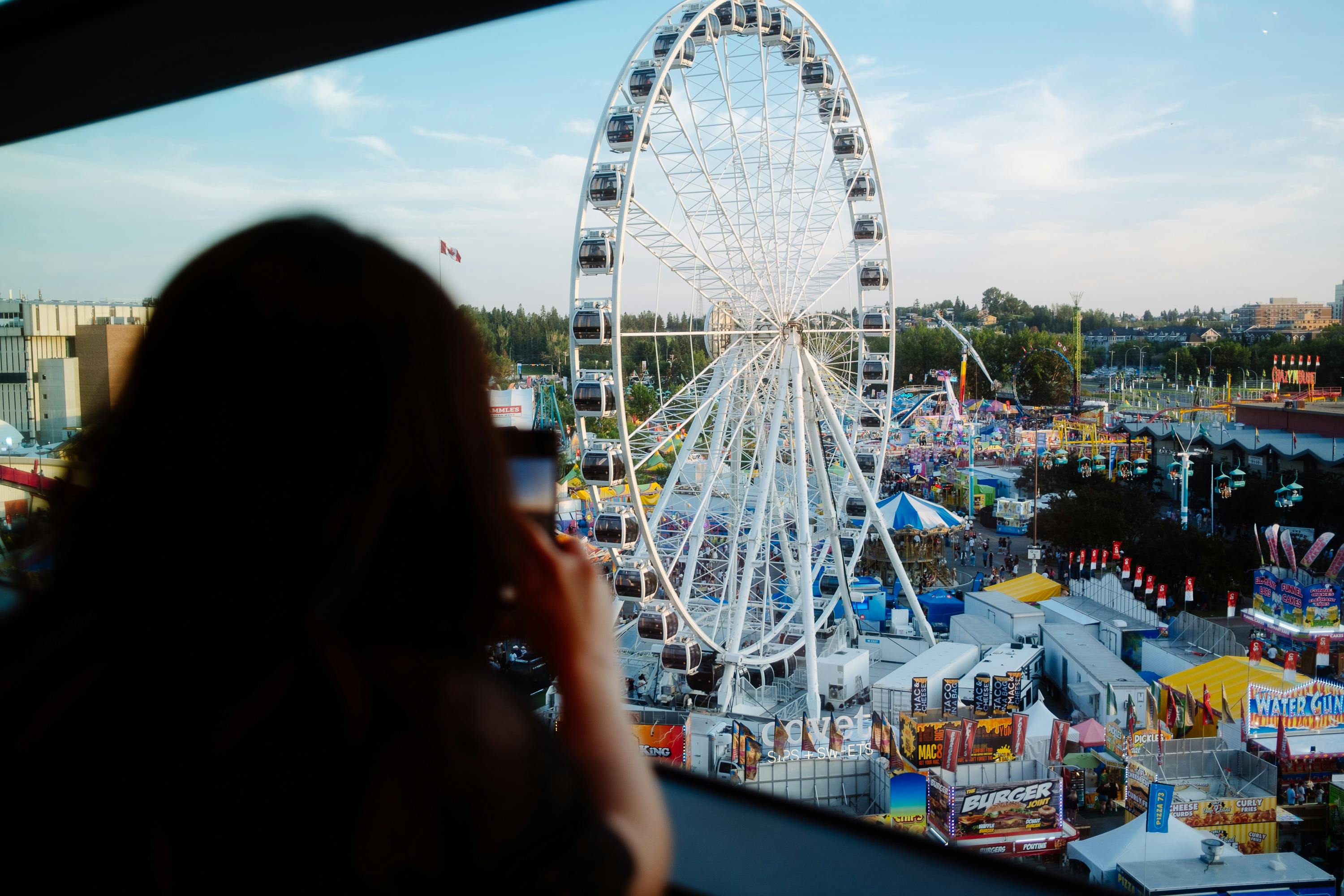 View of a Ferris wheel and fairground from above, with vibrant colors and lively atmosphere.