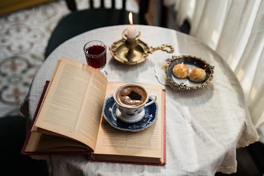 Elegant table with a coffee cup, open book, and pastries, evoking a cozy, vintage atmosphere.