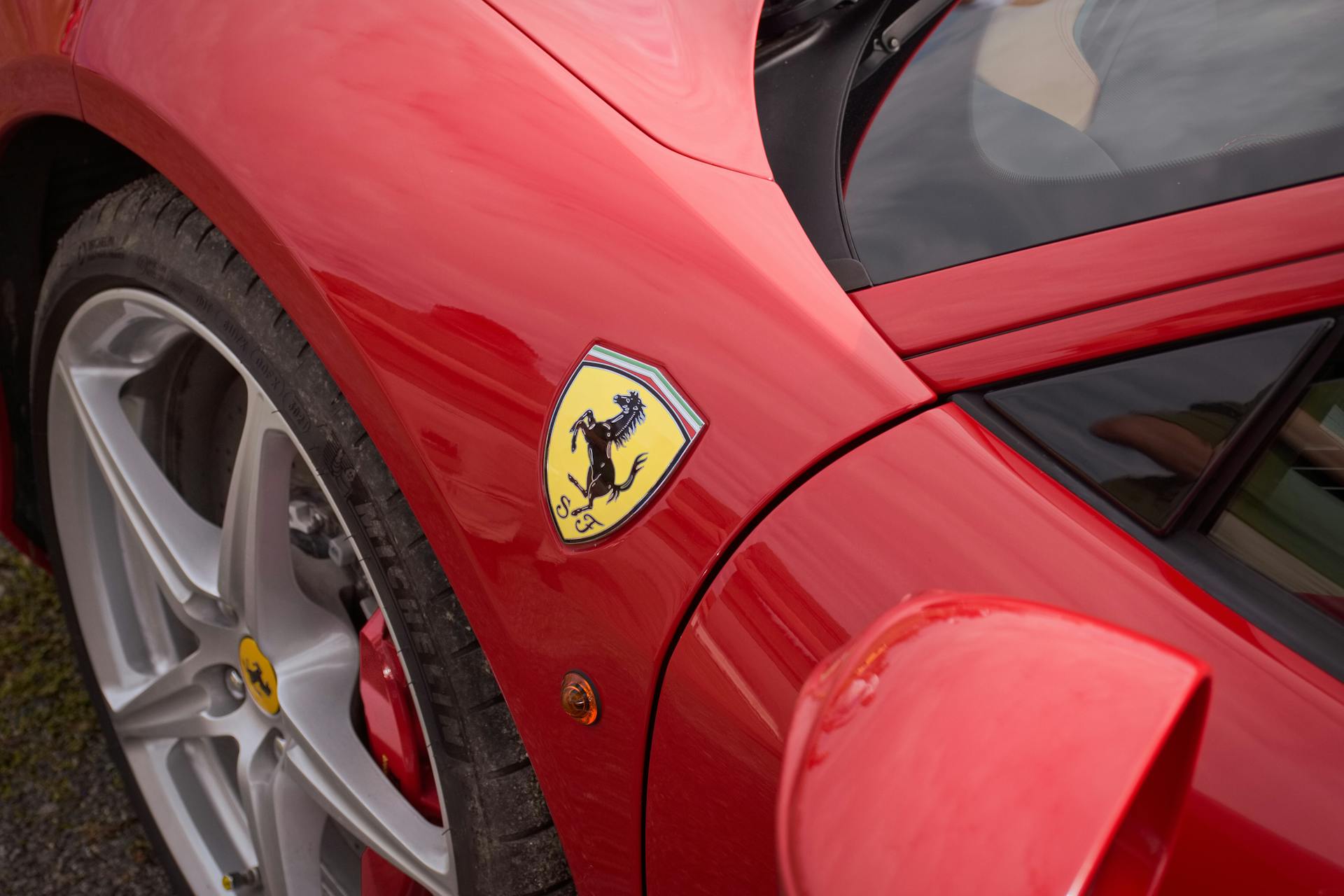 Detailed view of a red Ferrari showcasing its logo and sleek design.