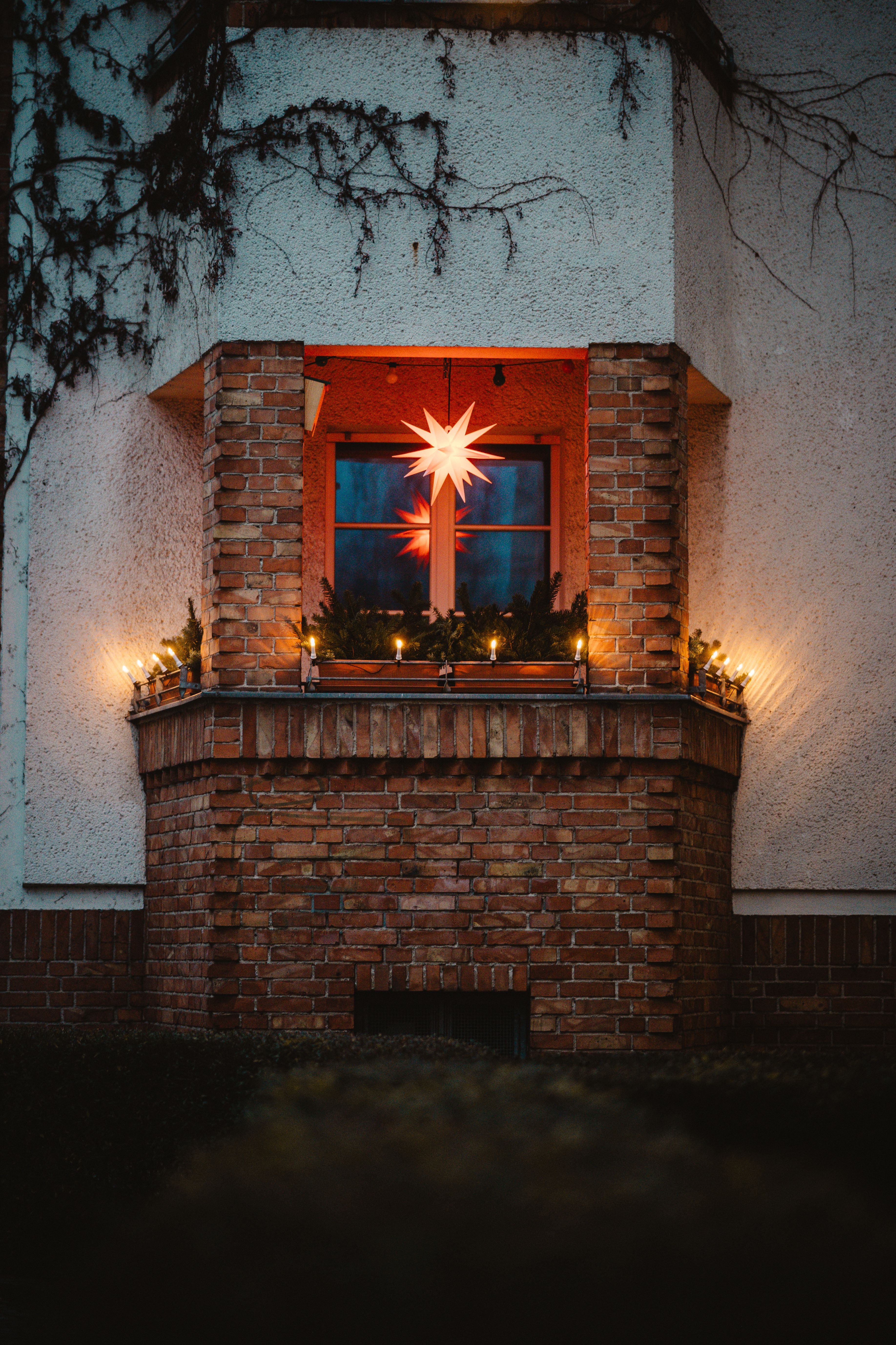 A beautifully decorated window in Berlin with a star light and festive lights.