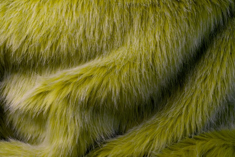 Detailed close-up of lime green faux fur texture, ideal for design backgrounds and natural aesthetics.