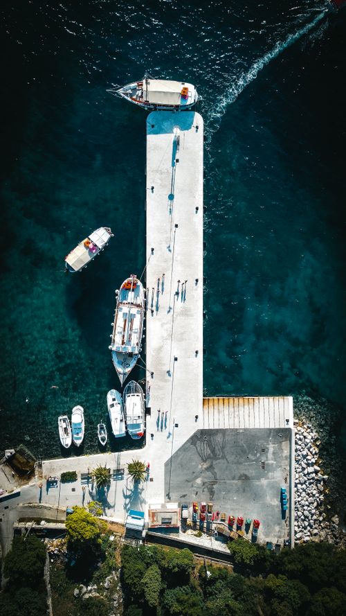 Free A stunning aerial view of a harbor with boats docked on a clear summer day. Stock Photo