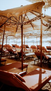 Cozy beachside lounge area with sun beds and umbrellas, perfect for relaxation.