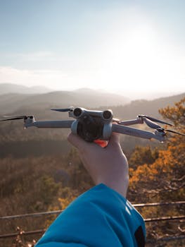 A drone is held against a scenic sunset backdrop in rural Germany, showcasing natural beauty.