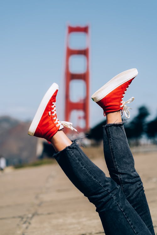Cerrar imagen de moda de pies de mujer, vistiendo jeans vintage y elegantes zapatillas  rojas, colores de tonos brillantes.