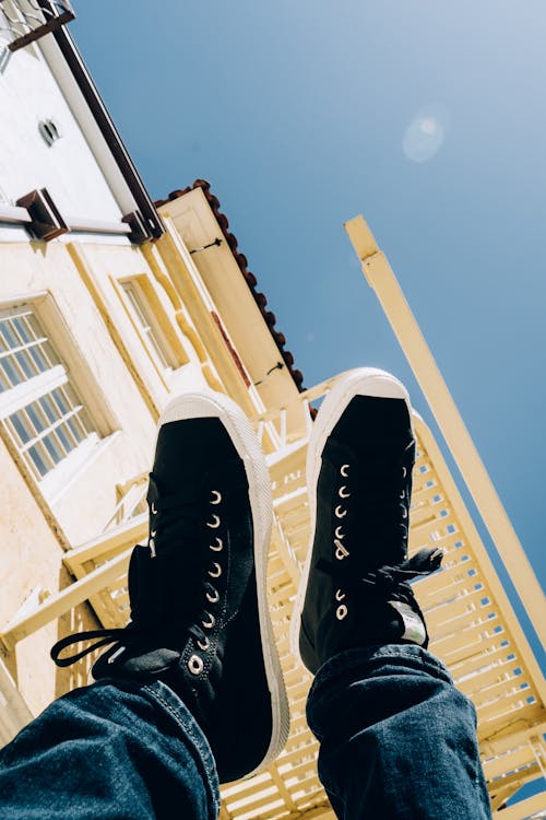 Person Raising Feet With Black-and-white Shoes