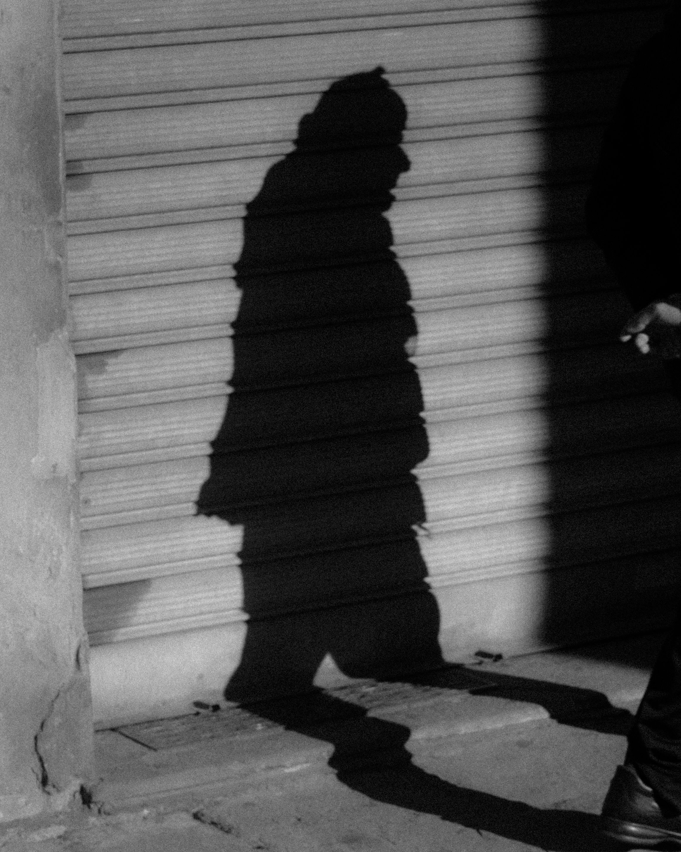 Gratis Silhouette di un'ombra in bianco e nero su una strada di Firenze, che cattura l'essenza urbana. Foto a disposizione