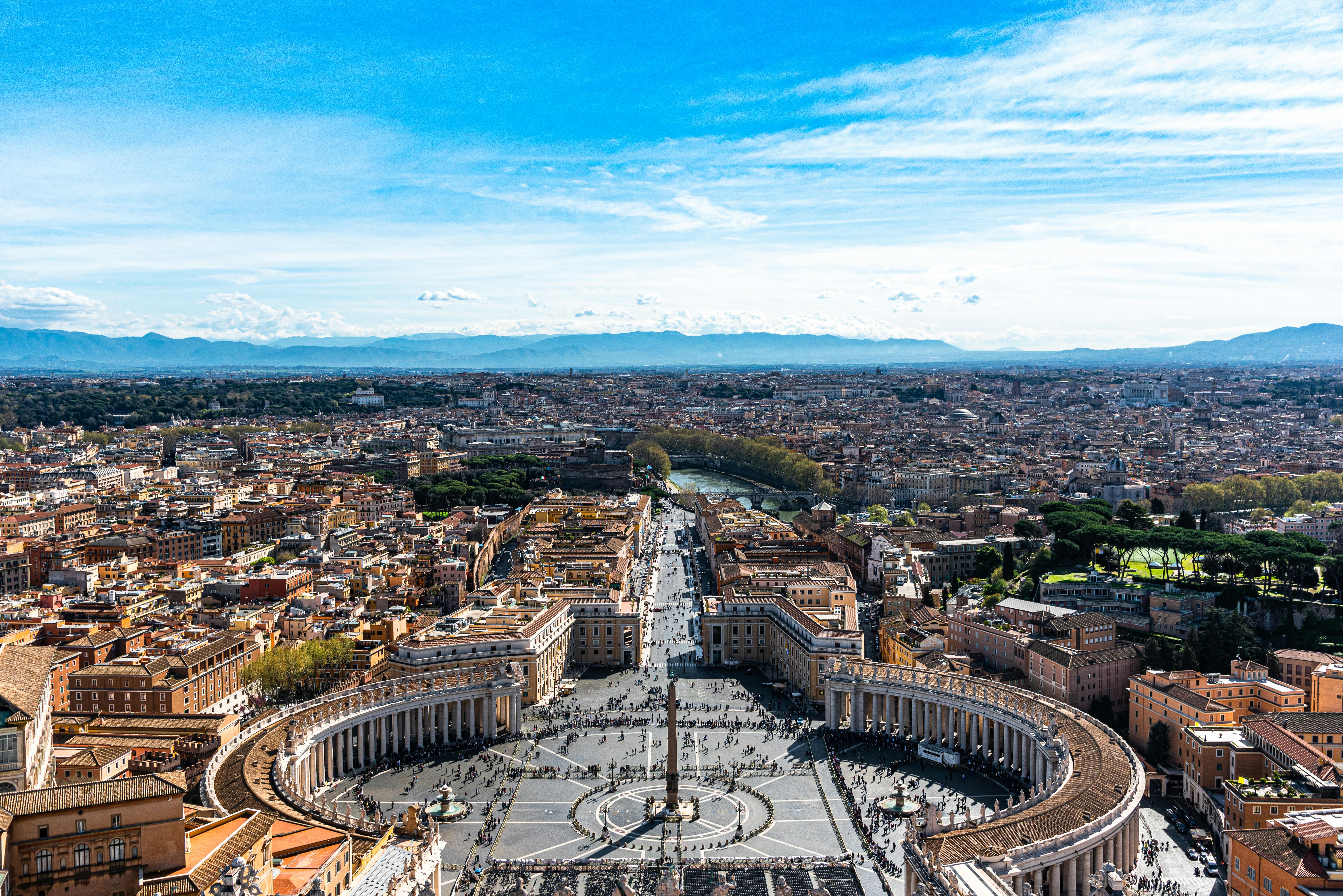 A stunning aerial view of St. Peter's Square in Vatican City with clear blue skies.
