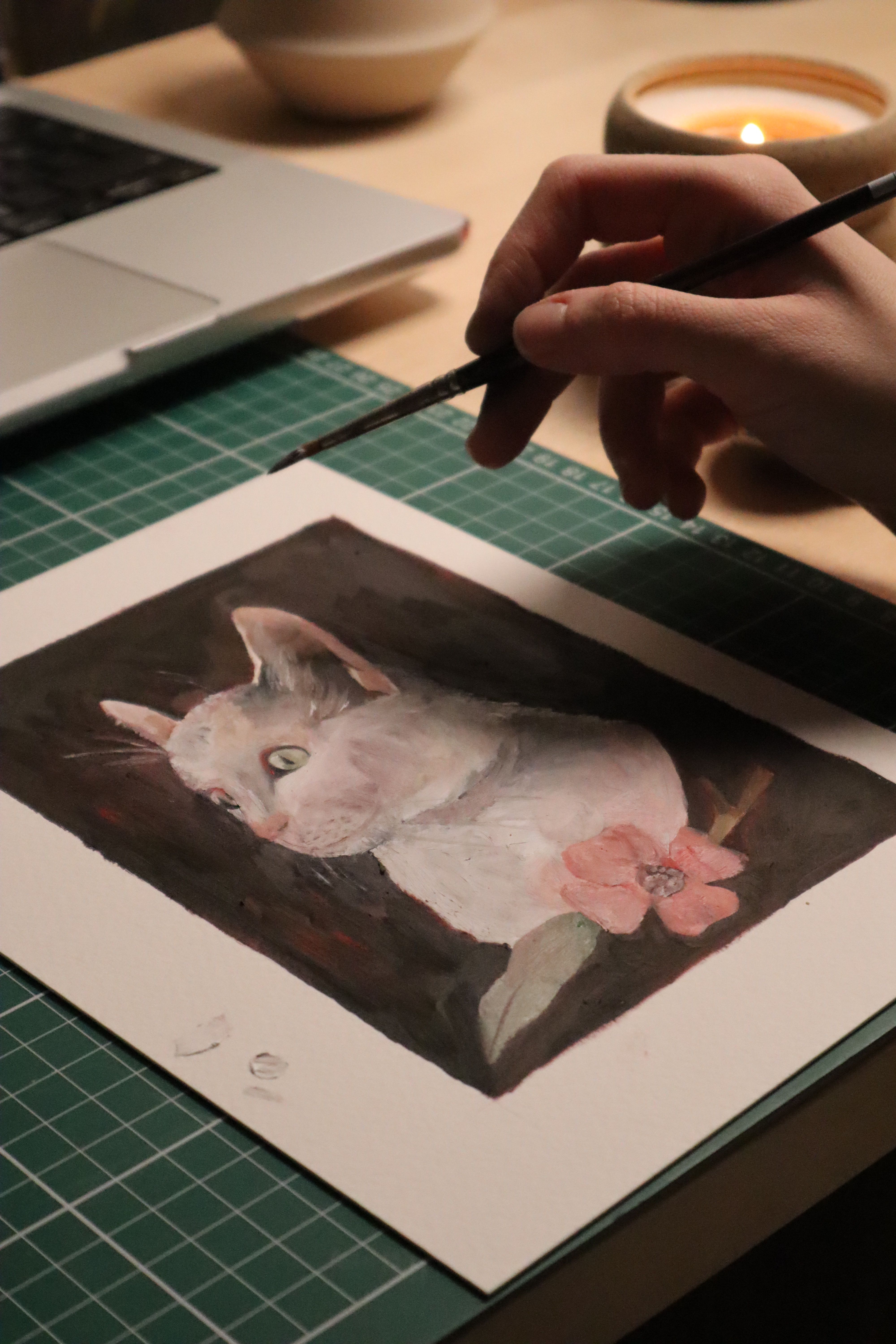 Artistic cat portrait being painted indoors, creating a warm and cozy ambiance.