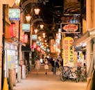 探索大阪繁华街头市场的热闹夜色，那里五彩缤纷的灯光和繁忙的商业景象交织