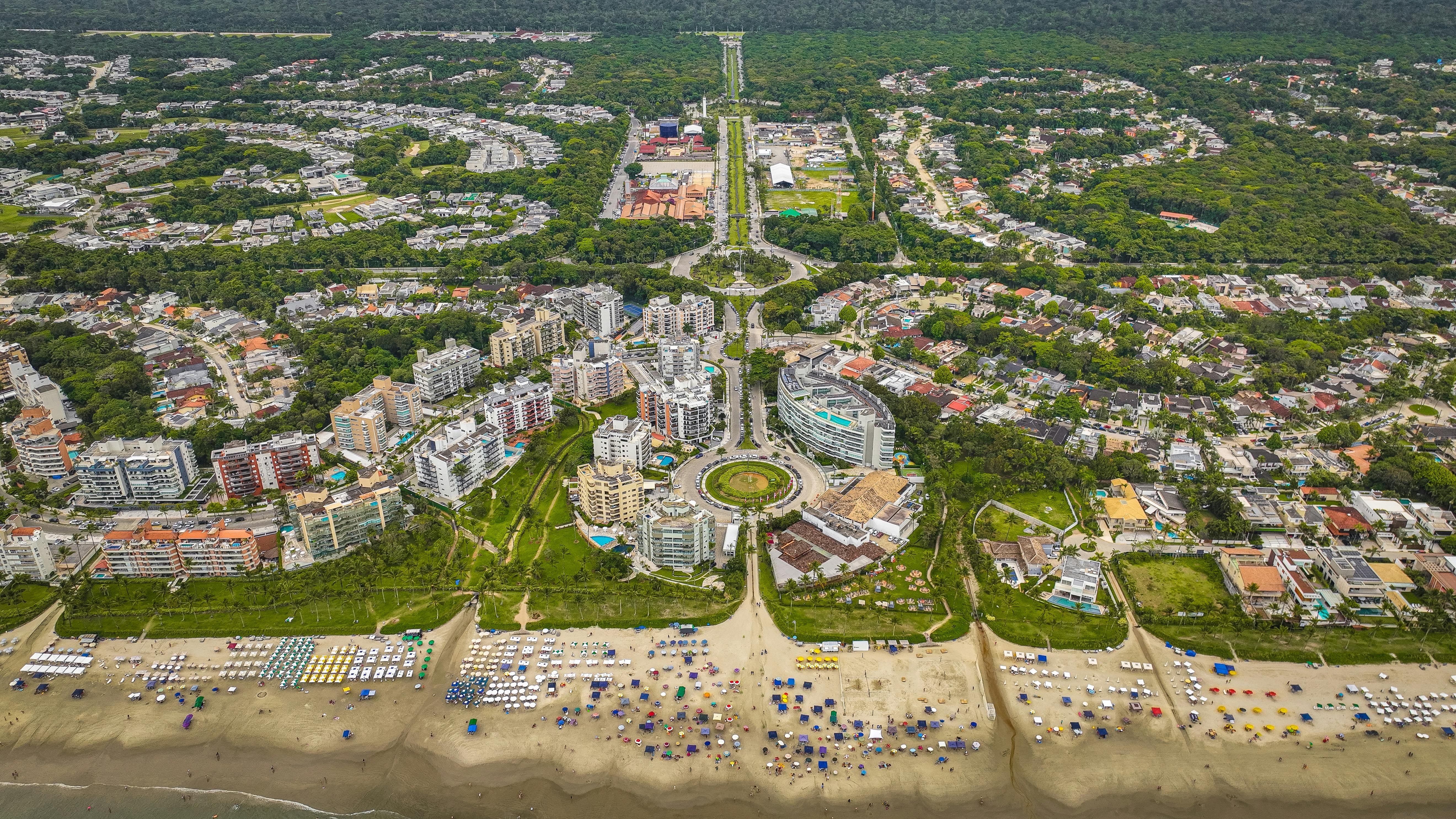 Vibrant aerial shot of a coastal city with beachfront and lush greenery.