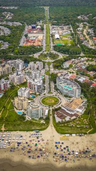 Stunning aerial view of a vibrant beachfront city with lush greenery and modern architecture.