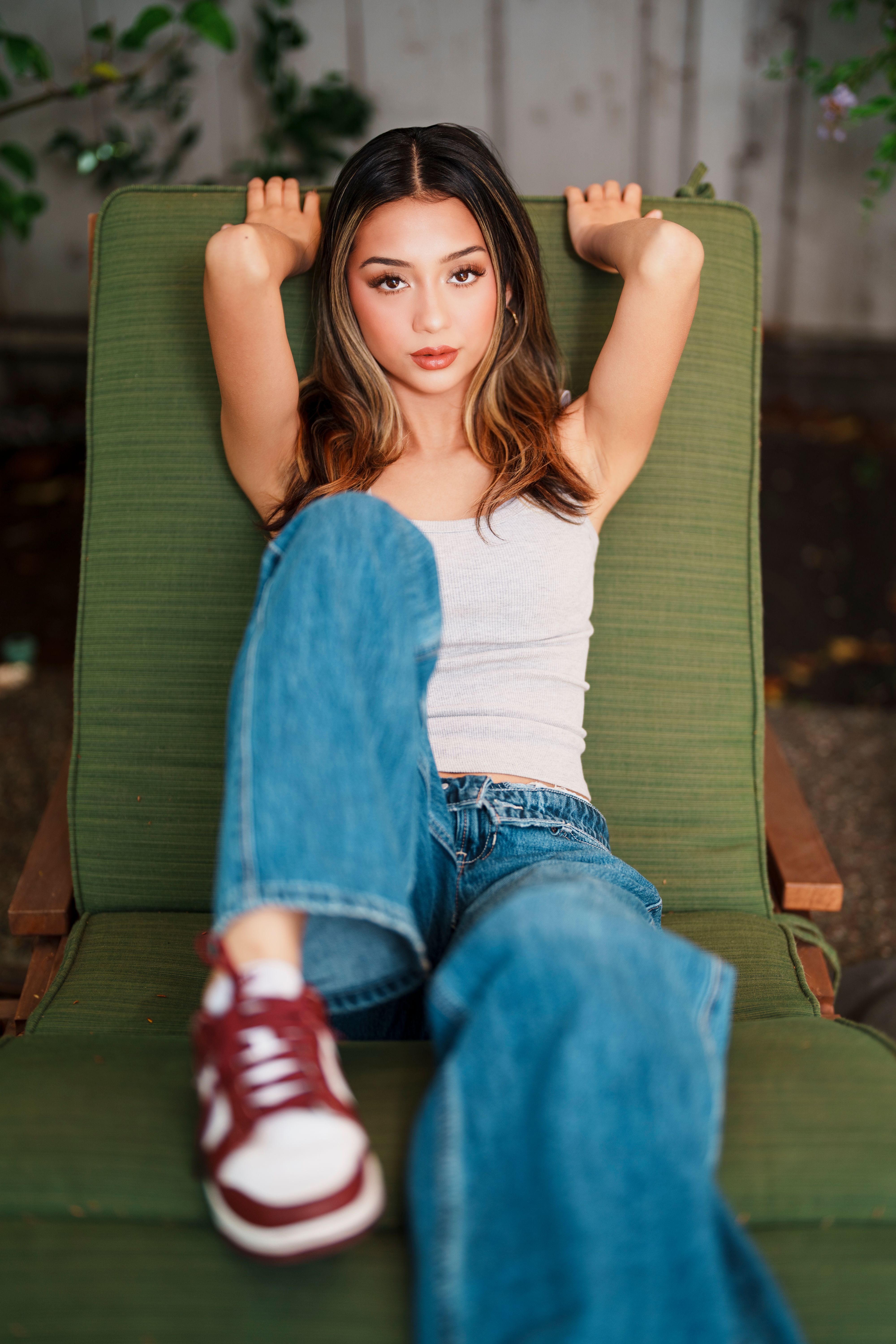 Relaxed young woman in casual attire lounging outdoors in Palo Alto.