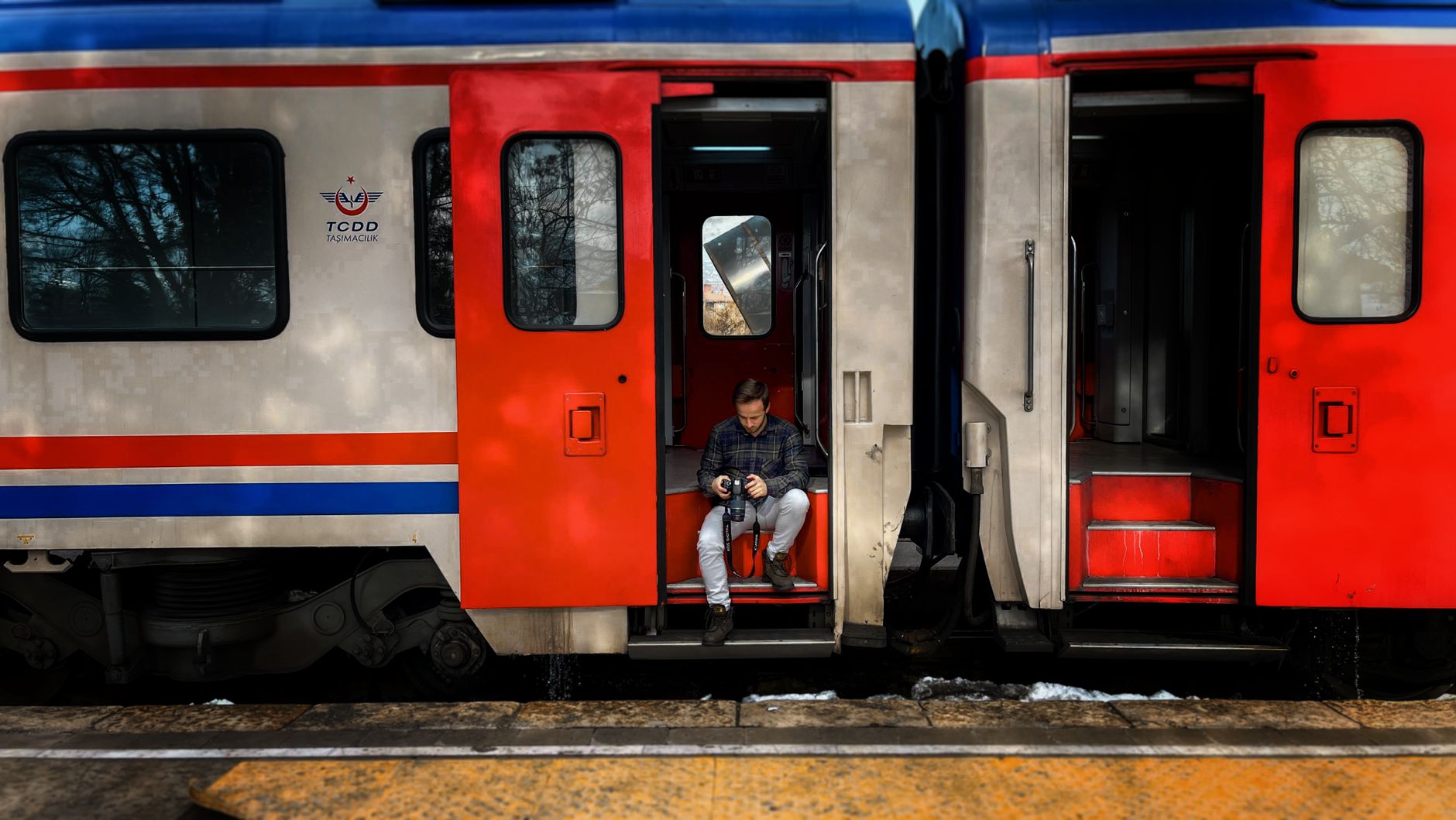 Traveler holding a camera while seated on a train