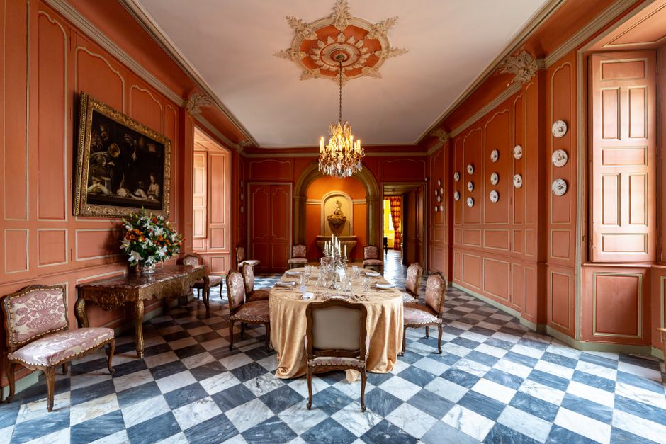 Elegant dining room featuring vintage decor, chandelier, and checkered flooring.