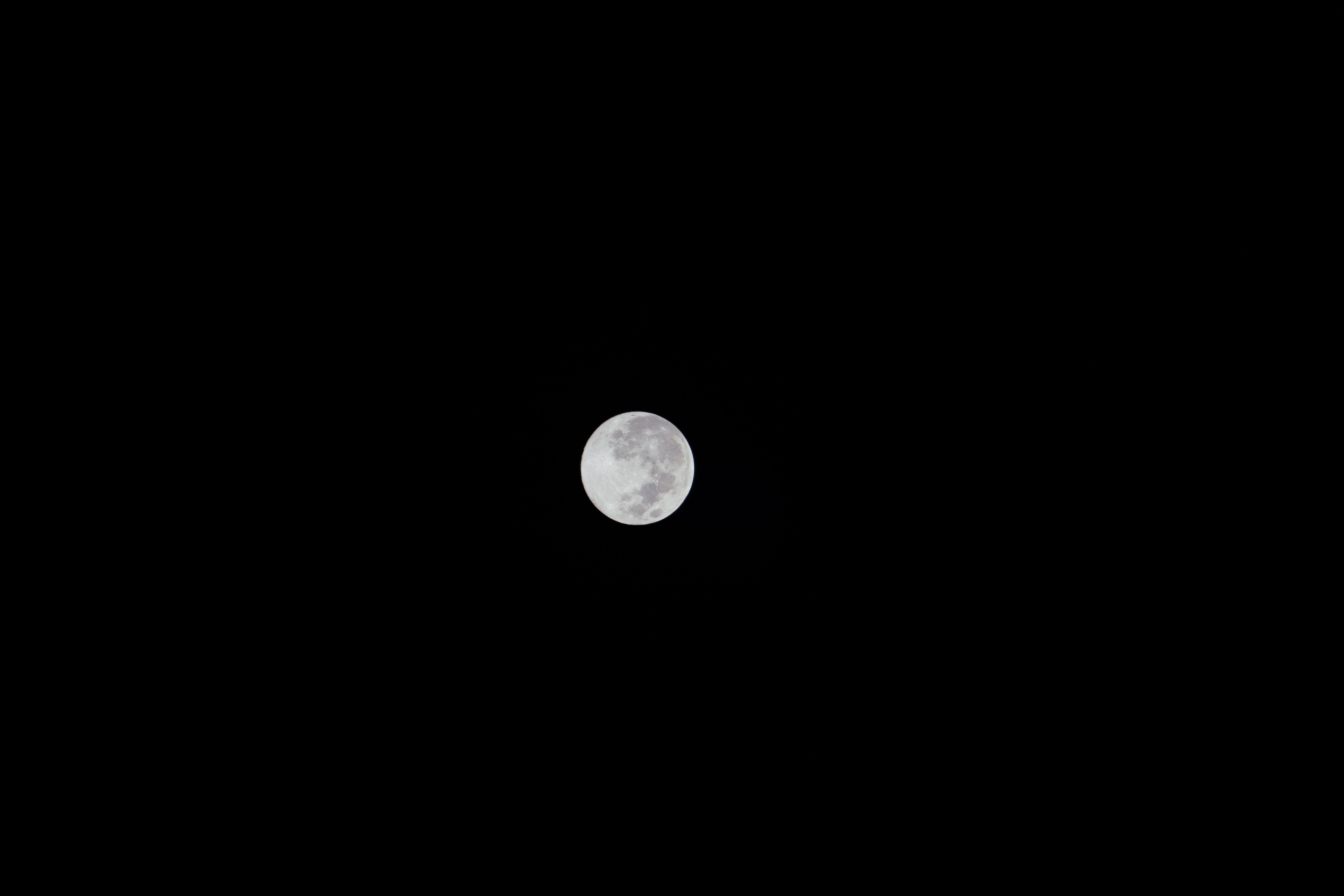 Une image nette de la pleine lune brillant dans un ciel nocturne sombre et clair.