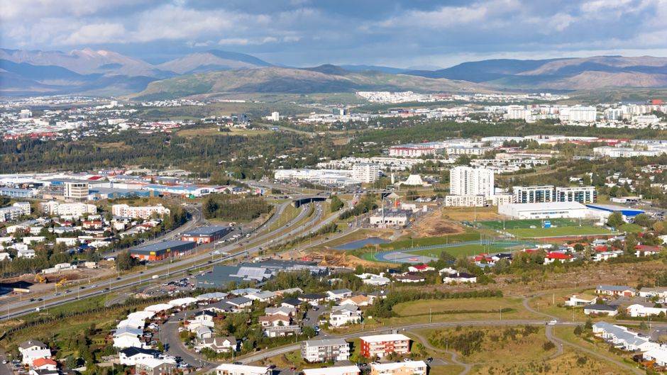 Flybus airport transfer bus parked in front of a scenic Icelandic landscape, ready to transport passengers to Reykjavík.