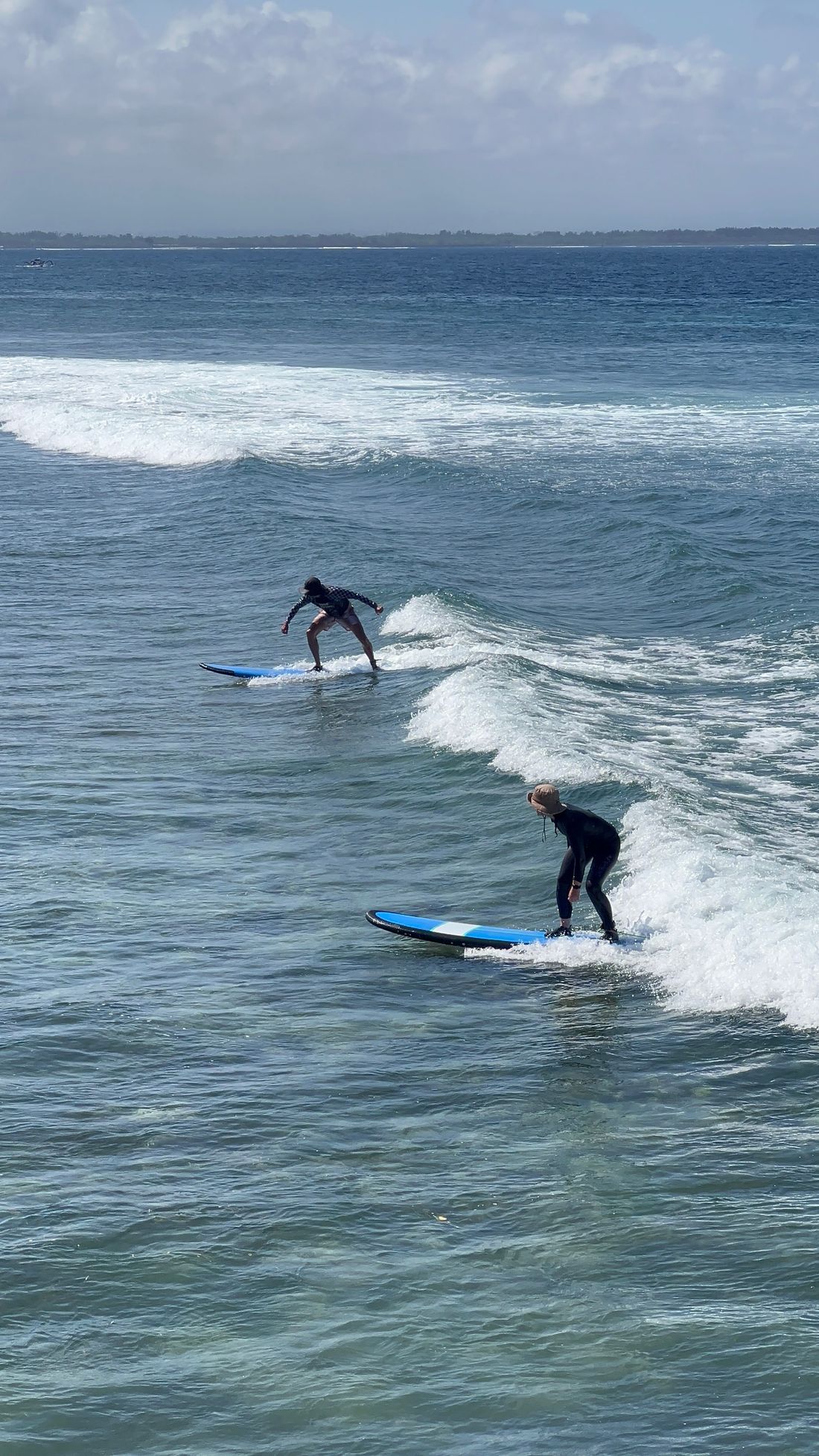 Surfers riding waves on a bright day