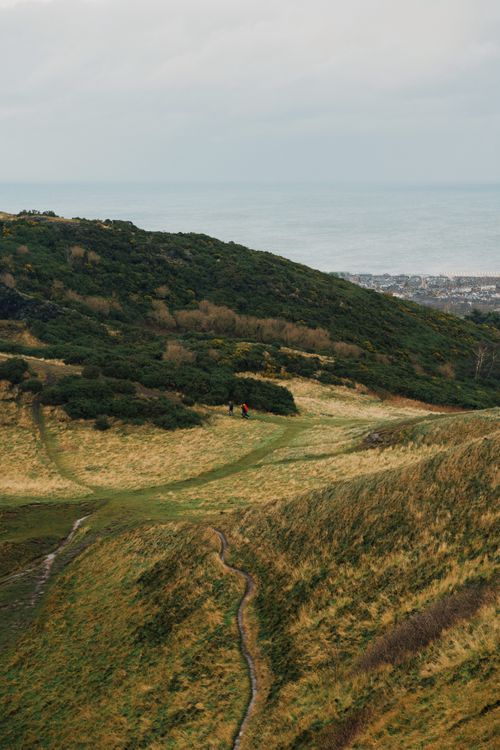Free Beautiful landscape of Edinburgh with lush green hills and sea in the distance. Stock Photo
