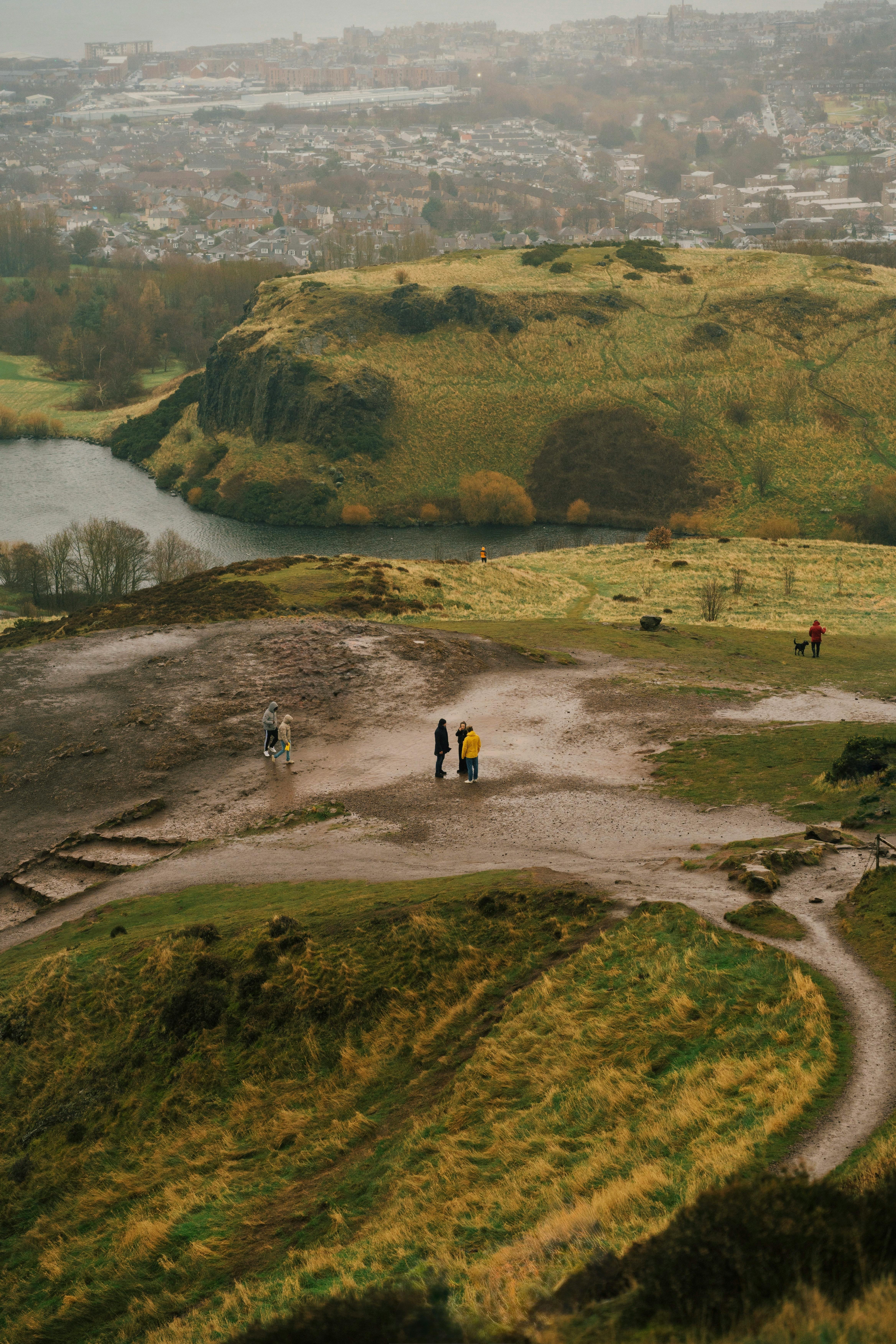 A breathtaking view of Arthur's Seat in Edinburgh with hikers exploring the landscape.
