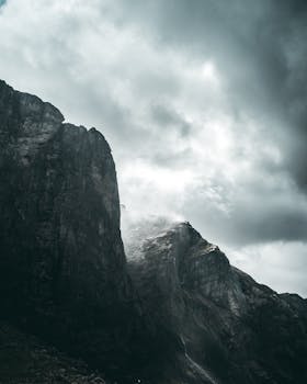 Moody Norwegian cliffs and fjord under stormy skies.