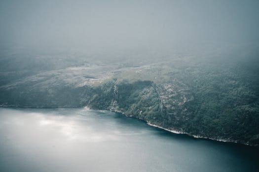 薄雾笼罩的山地景观迷人，水体宁静