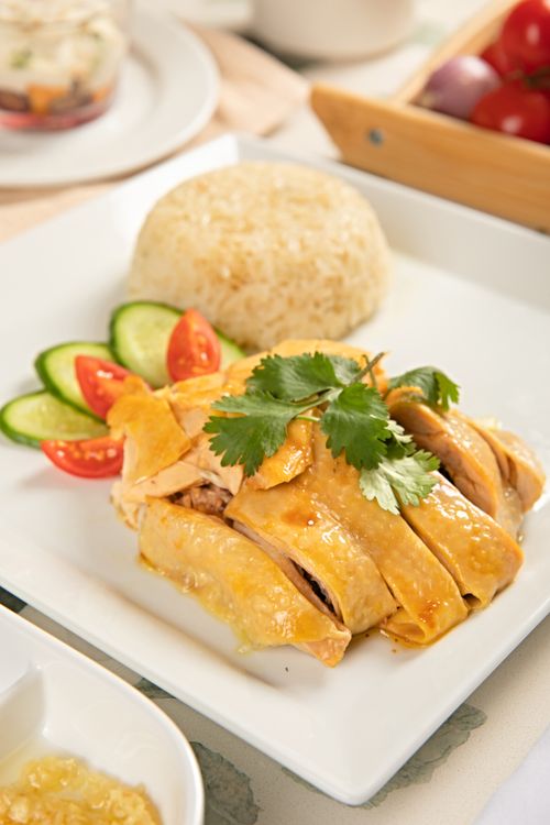 Free Appetizing chicken rice dish served with cucumbers and tomatoes. Stock Photo