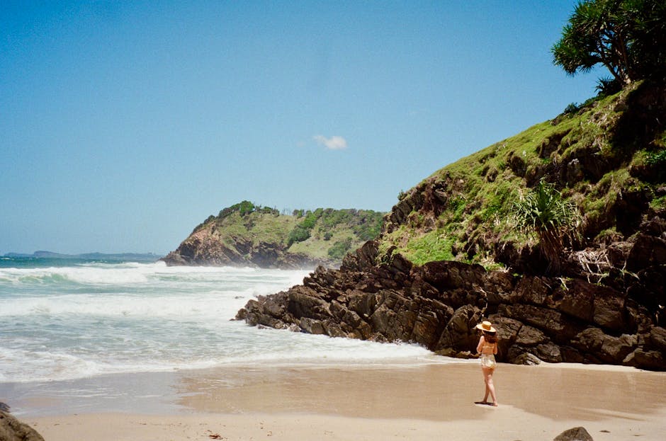 A serene beach scene at Broken Head, NSW, with a lone woman enjoying the view.