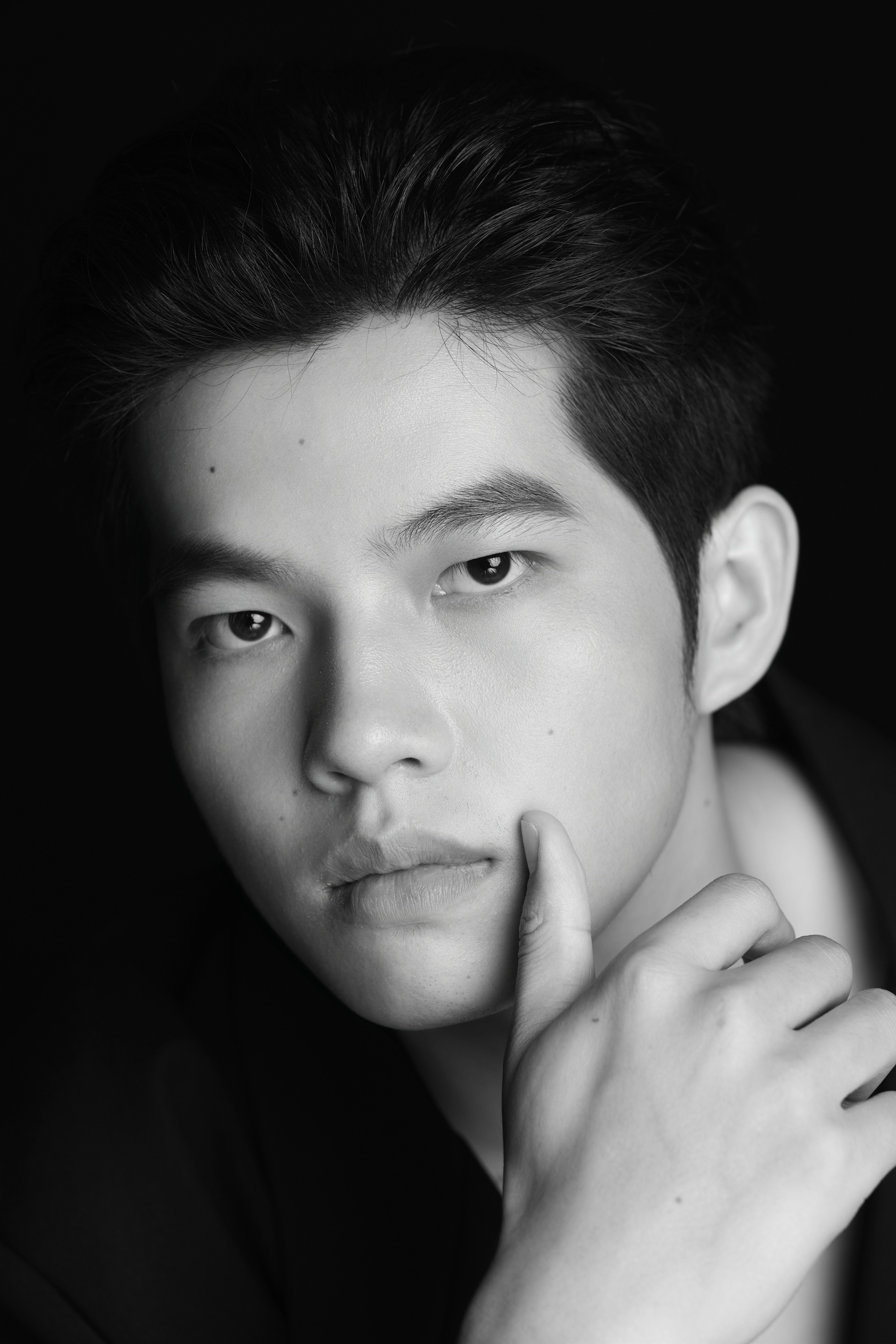 Thoughtful black and white portrait of a young man with a contemplative expression.