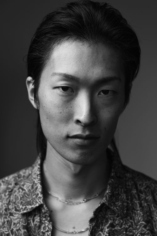 Free Captivating black and white close-up portrait of a young man with an enigmatic expression. Stock Photo